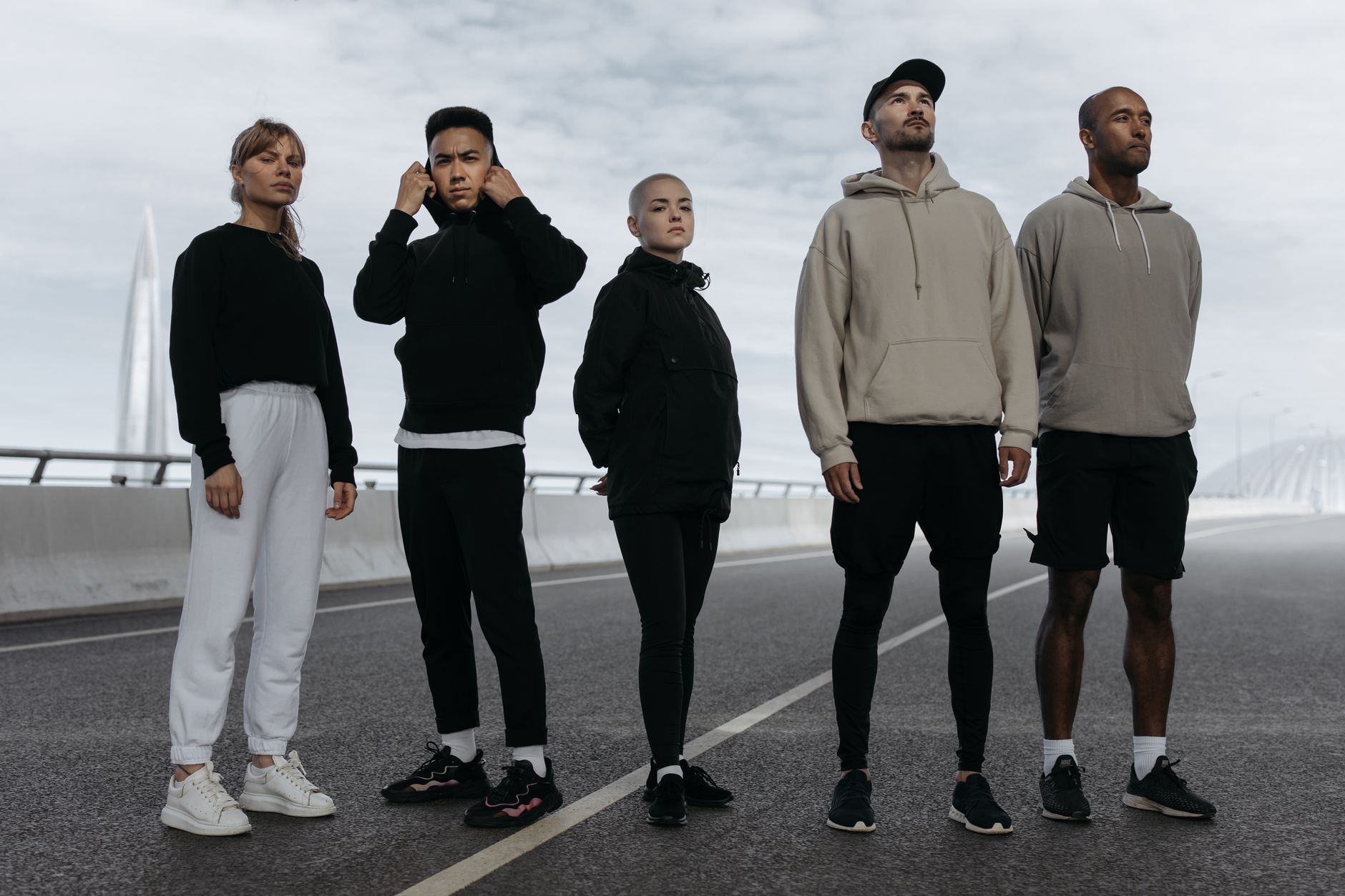 A diverse group of young adults in activewear standing confidently on a road, showcasing modern sports fashion. — H Cup Bra: